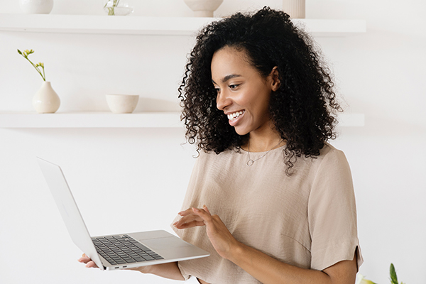 Woman holding laptop smiling