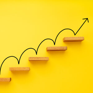 Steps on a yellow background with a hand-drawn arrow bouncing up the steps
